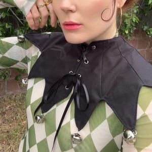 May include: A white ceramic mug with a black handle and the text "But First, Coffee" in a bold, black font. The mug is set against a blurred background, suggesting a cozy setting.