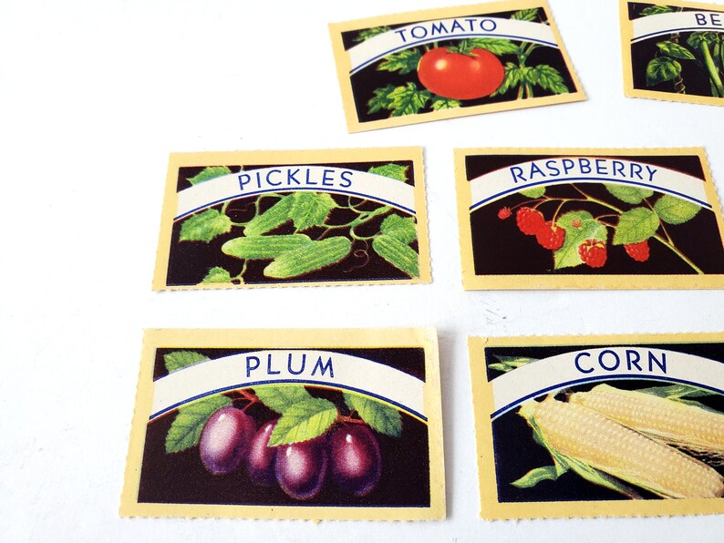 May include: Six vintage yellow cards with blue and white text and illustrations of various fruits and vegetables. The cards read "TOMATO", "PICKLES", "RASPBERRY", "PLUM", "CORN", and "BEANS".