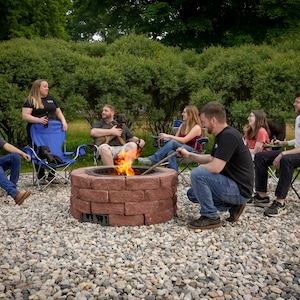 Fire pit in action with clean-burning flames and a group of friends enjoying eachother's company around it.