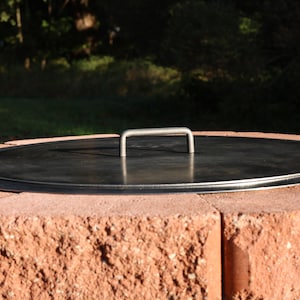 Top view of a solid steel fire pit lid, raw finish, showing durable construction and clean edges lays flat without a gap when finished.