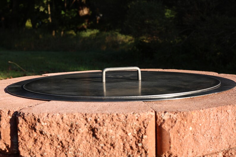 Top view of a solid steel fire pit lid, raw finish, showing durable construction and clean edges lays flat without a gap when finished.