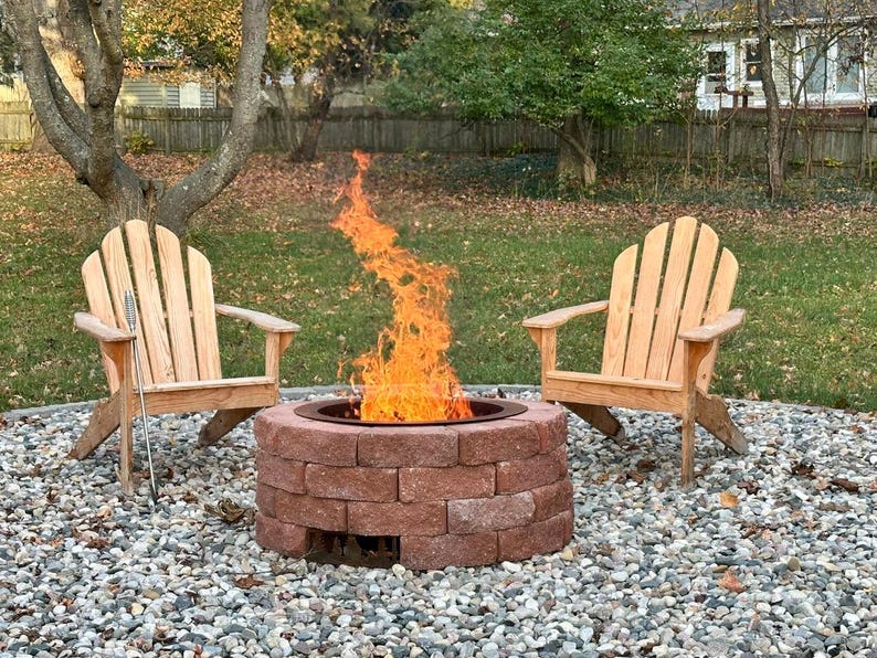 Raw steel DIY smokeless fire pit kit, with visible natural patina from outdoor use with sizeable smokeless fire with two chairs.