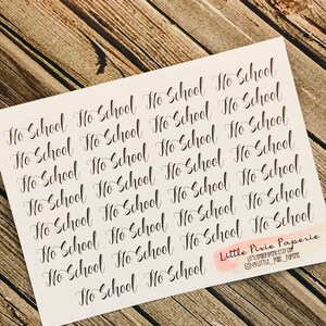 May include: A sheet of white paper with the phrase "No School" repeated 16 times in black cursive writing. The text is arranged in a grid pattern. The paper is on a woodgrain background. The bottom right corner of the paper has a small logo that reads "Little Pixie Paperie" with a website and social media handle.
