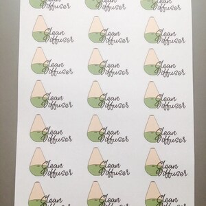 May include: A sheet of stickers featuring a stylized illustration of an essential oil diffuser. Each sticker has a light beige top, a green base, and the words "Clean Diffuser" in a cursive font. The stickers are on a white background.
