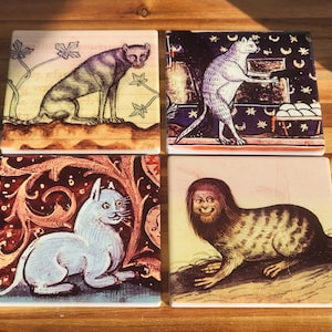 Puede incluir: Juego de cuatro posavasos cuadrados de cer&aacute;mica con ilustraciones de gatos de estilo medieval. Cada posavasos muestra un dise&ntilde;o de gato &uacute;nico en varias poses, con una est&eacute;tica vintage. La paleta de colores incluye tonos de marr&oacute;n, beige y rojo.