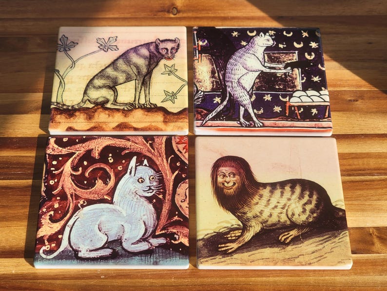 Puede incluir: Juego de cuatro posavasos cuadrados de cer&aacute;mica con ilustraciones de gatos de estilo medieval. Cada posavasos muestra un dise&ntilde;o de gato &uacute;nico en varias poses, con una est&eacute;tica vintage. La paleta de colores incluye tonos de marr&oacute;n, beige y rojo.