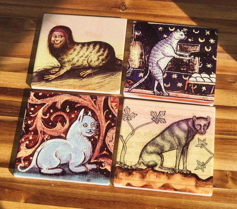 Puede incluir: Juego de cuatro posavasos cuadrados de cer&aacute;mica con ilustraciones de estilo medieval de criaturas fant&aacute;sticas y gatos. Los posavasos tienen un acabado brillante y est&aacute;n colocados sobre una superficie de madera. Cada uno tiene un dise&ntilde;o &uacute;nico.