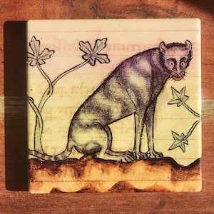 Puede incluir: Azulejo cer&aacute;mico cuadrado con una ilustraci&oacute;n estilizada de una criatura felina sentada con una larga cola. La obra de arte est&aacute; en tonos de morado, marr&oacute;n y verde, con elementos vegetales. El azulejo tiene una est&eacute;tica vintage.