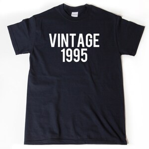 May include: A black t-shirt with white text that reads "Vintage 1995".