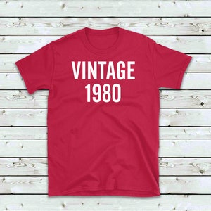 May include: Red t-shirt with white text that reads "Vintage 1980".