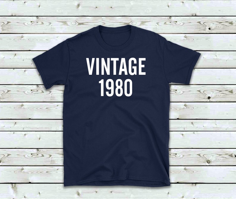 May include: A navy blue t-shirt with white text that reads "Vintage 1980".