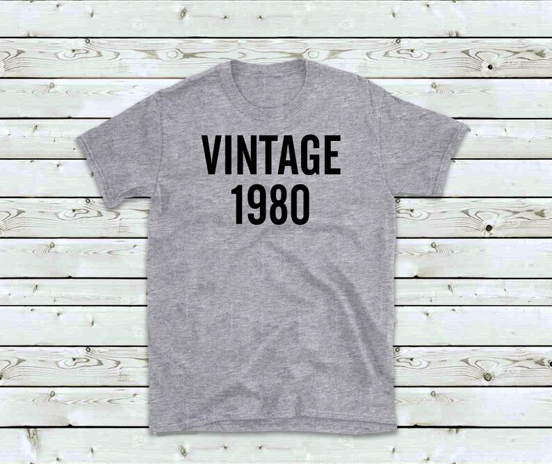 May include: A gray t-shirt with black text that reads "Vintage 1980".