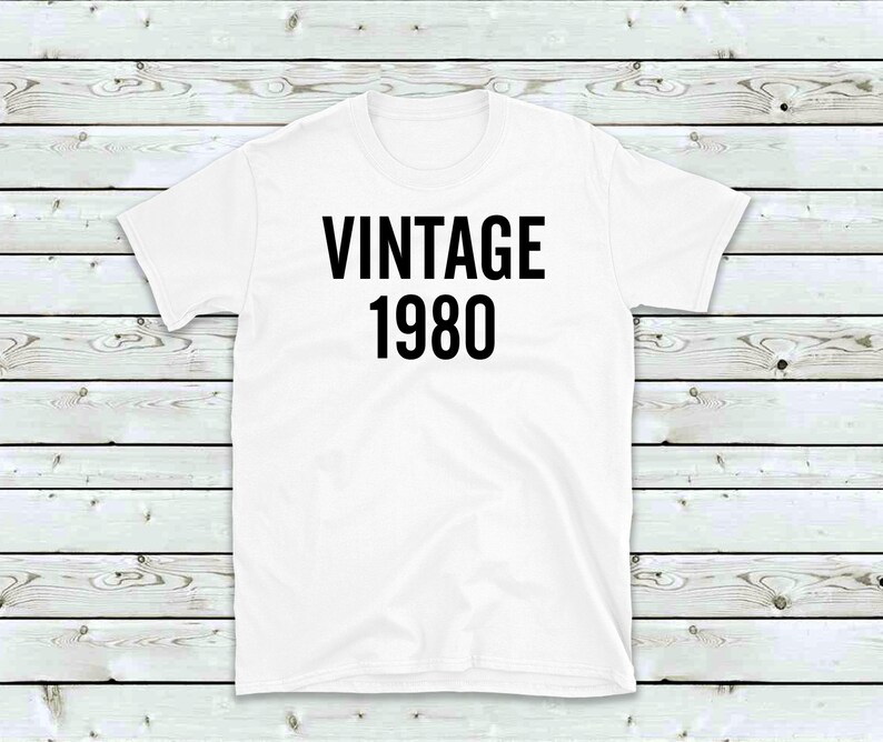 May include: White t-shirt with black text that reads "Vintage 1980".