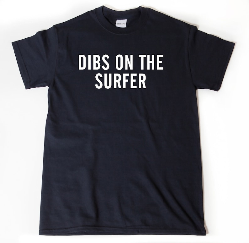 May include: A black t-shirt with white text that reads "DIBS ON THE SURFER".