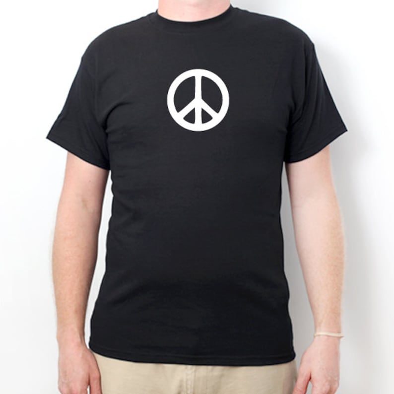 May include: A black t-shirt with a white peace sign graphic on the front.