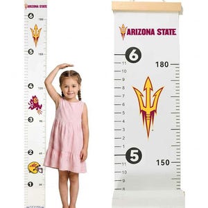 May include: A white canvas growth chart with a wooden hanger at the top, featuring the Arizona State logo, the text "ARIZONA STATE", and "FUTURE TAILGATER". The chart displays measurements in both feet and inches, as well as centimeters up to 180 cm.