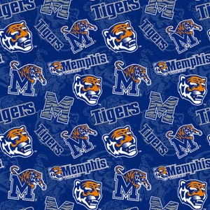 May include: A blue fabric with a repeating pattern of Memphis Tigers logos. The design includes the team's tiger head logo, the letter "M", and the word "Tigers" in white and orange. The background has a subtle, textured effect.