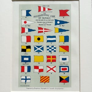 Puede incluir: Impresión enmarcada del Código Internacional de Señales, con banderas de colores que representan letras y señales. La impresión incluye texto de la Junta de Comercio y está preparada para uso de todas las naciones.