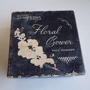 May include: A vintage black box with a white floral design and the text "Simpsons Floral Bower Face Powder".