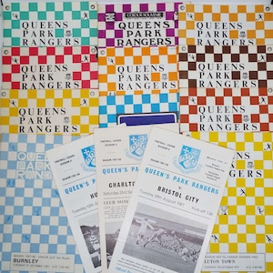 Puede incluir: Una colección de programas y folletos de recuerdo de fútbol de los Queens Park Rangers. Las portadas presentan el nombre del equipo en negrita, sobre un fondo a cuadros de varios colores. Algunos programas muestran detalles de los partidos.