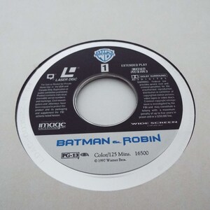 May include: A white laser disc with a black center featuring the Warner Bros. logo and the title "Batman & Robin". The disc is rated PG-13 and has a runtime of 125 minutes. The text "Color/125 Mins. 16500 &copy; 1997 Warner Bros." is printed on the disc.