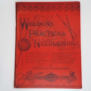 May include: Red book cover with the title "Weldon's Practical Needlework" in black lettering. The cover features illustrations of knitting needles, yarn, and scissors. The book includes instructions for knitting, crocheting, and other needlework techniques. It also states that it includes nearly 500 engravings.