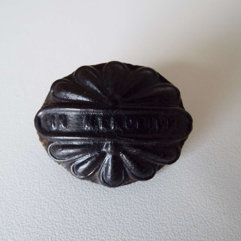 May include: Black leather seal with a floral design and the text "In Memoriam" embossed on the front.