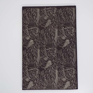 Puede incluir: Textil rectangular marr&oacute;n oscuro con un patr&oacute;n repetido de dibujos lineales blancos. El dise&ntilde;o presenta monos colgados de lianas, cocodrilos y follaje. La est&eacute;tica general recuerda a una impresi&oacute;n vintage.