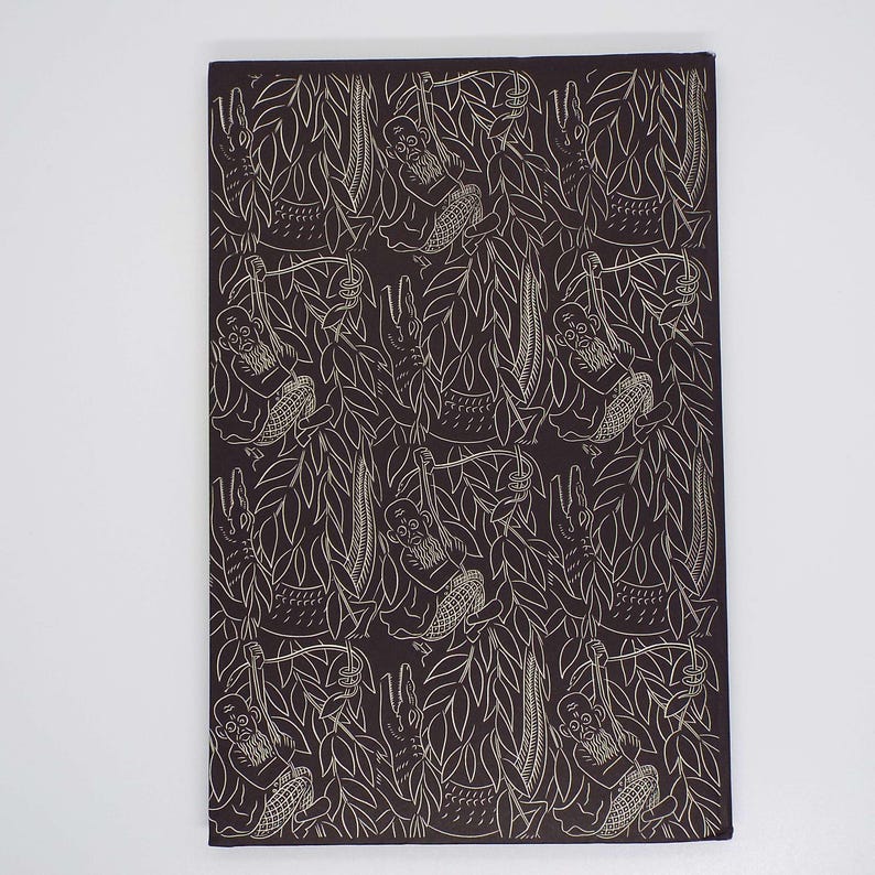 Puede incluir: Textil rectangular marr&oacute;n oscuro con un patr&oacute;n repetido de dibujos lineales blancos. El dise&ntilde;o presenta monos colgados de lianas, cocodrilos y follaje. La est&eacute;tica general recuerda a una impresi&oacute;n vintage.