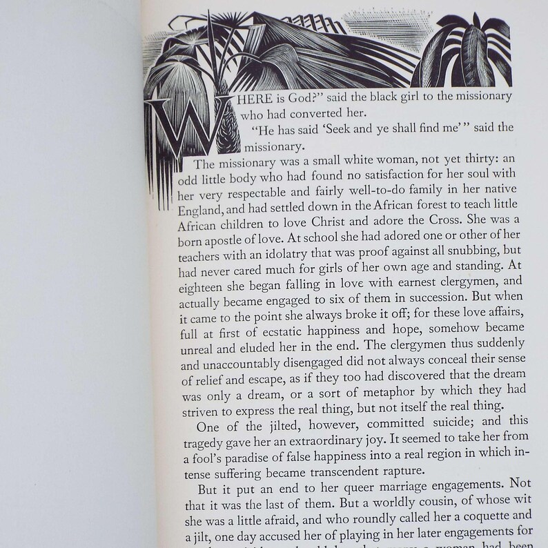 Puede incluir: P&aacute;gina de un libro abierto con texto e ilustraci&oacute;n. El texto comienza con una cita, "HERE is God?" y contin&uacute;a con una narrativa sobre una misionera y una ni&ntilde;a negra. La ilustraci&oacute;n presenta una gran "W" y un dibujo de una persona.