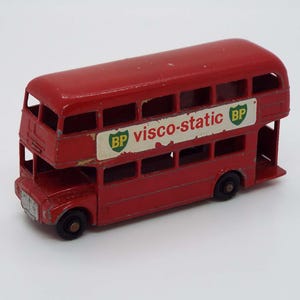 May include: A red double-decker bus toy with "BP visco-static" and "BP" logos on the side.