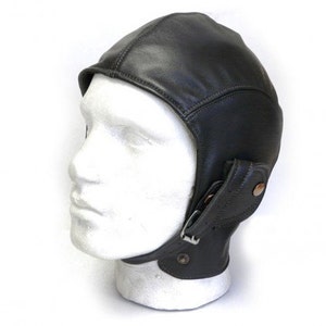 Könnte beinhalten: Ein schwarzer Lederfliegerhelm mit Ohrenschützern und einem Schnallenverschluss.