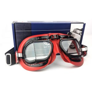 Könnte beinhalten: Rote Leder-Fliegerbrille mit schwarzem Rahmen und klaren Gläsern. Die Brille hat ein Band und ist mit "Halcyon" und "Made in England" beschriftet.