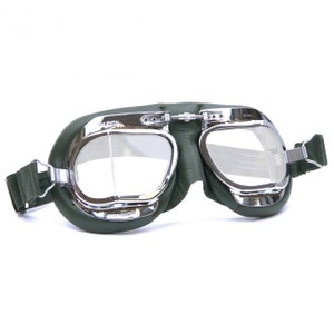 Könnte beinhalten: Grüne Leder-Fliegerbrille mit verchromten Metallrahmen und klaren Gläsern. Die Brille hat ein Band aus grünem Stoff.