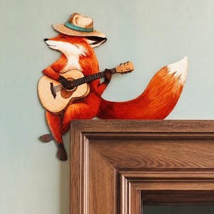 Peut inclure: Une décoration murale en bois représentant un renard portant un chapeau beige avec une bande bleue, jouant d'une guitare acoustique claire. Le renard a un pelage orange avec le poitrail et le bout de la queue blancs. Texte DOOR STORIES by Dear Prudence.