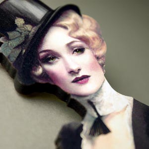 Può includere: Immagine in stile vintage di una donna con un cappello a cilindro nero e abbigliamento formale. La donna ha i capelli biondi, occhi verdi e indossa rossetto scuro. L'immagine ha un'estetica classica e artistica.