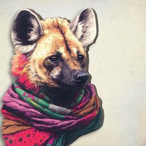 Può includere: Primo piano di un cane selvatico con una sciarpa colorata intorno al collo. Il cane ha la pelliccia marrone e un naso nero. La sciarpa è fatta di diversi tessuti e colori, tra cui rosa, verde e marrone.