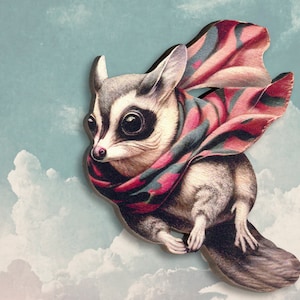 May include: A small, gray and white animal with large eyes wearing a pink and green scarf, flying through the clouds.