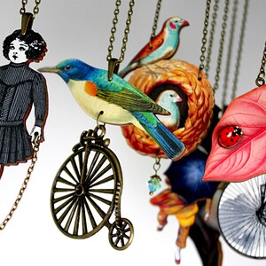 May include: A collection of necklaces with various charms, including a girl in a black dress, a blue bird, a bird's nest, a leaf with a ladybug, and a bicycle. The necklaces are made of metal chains and have a vintage aesthetic.