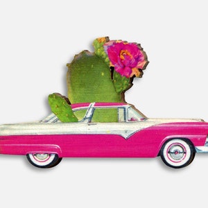 May include: A pink and white vintage car with a cactus and pink flower growing out of the back window.