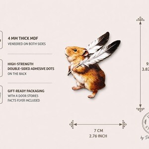 May include: A brown hamster wall decal holding two white and black feathers. The product is 4 mm thick MDF, measures 9.7 cm by 7 cm, and includes high-strength double-sided adhesive dots and gift-ready packaging with a facts flyer.