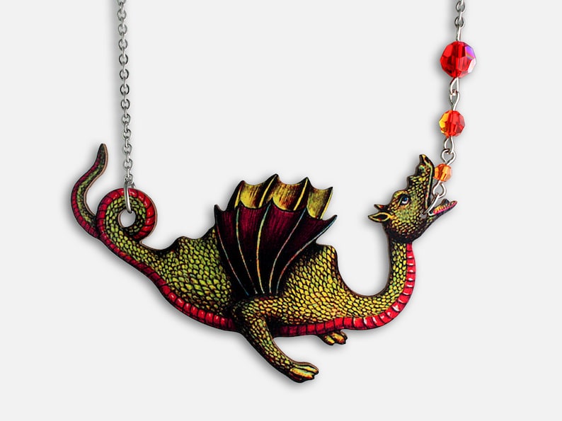 May include: A green and red dragon pendant necklace with a silver chain and red crystal beads. The dragon is depicted with wings and a long tail.