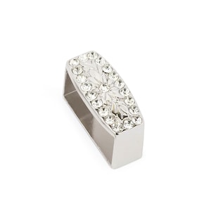 May include: Silver-toned belt buckle with a rectangular shape and a floral design set with clear rhinestones.