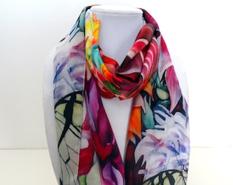 May include: A colorful silk scarf with a floral and butterfly print. The scarf is tied around a white mannequin's neck.