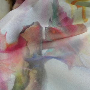 May include: Abstract watercolor print on a sheer fabric with shades of pink, green, blue, and yellow.
