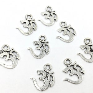 May include: Eight silver Om symbol charms with a distressed finish. The charms have a hole at the top for attaching to jewelry or other crafts.