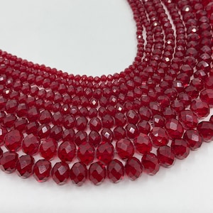 Peut inclure: Un brin de perles de verre facettées rouges. Les perles sont rondes et ont une finition brillante.