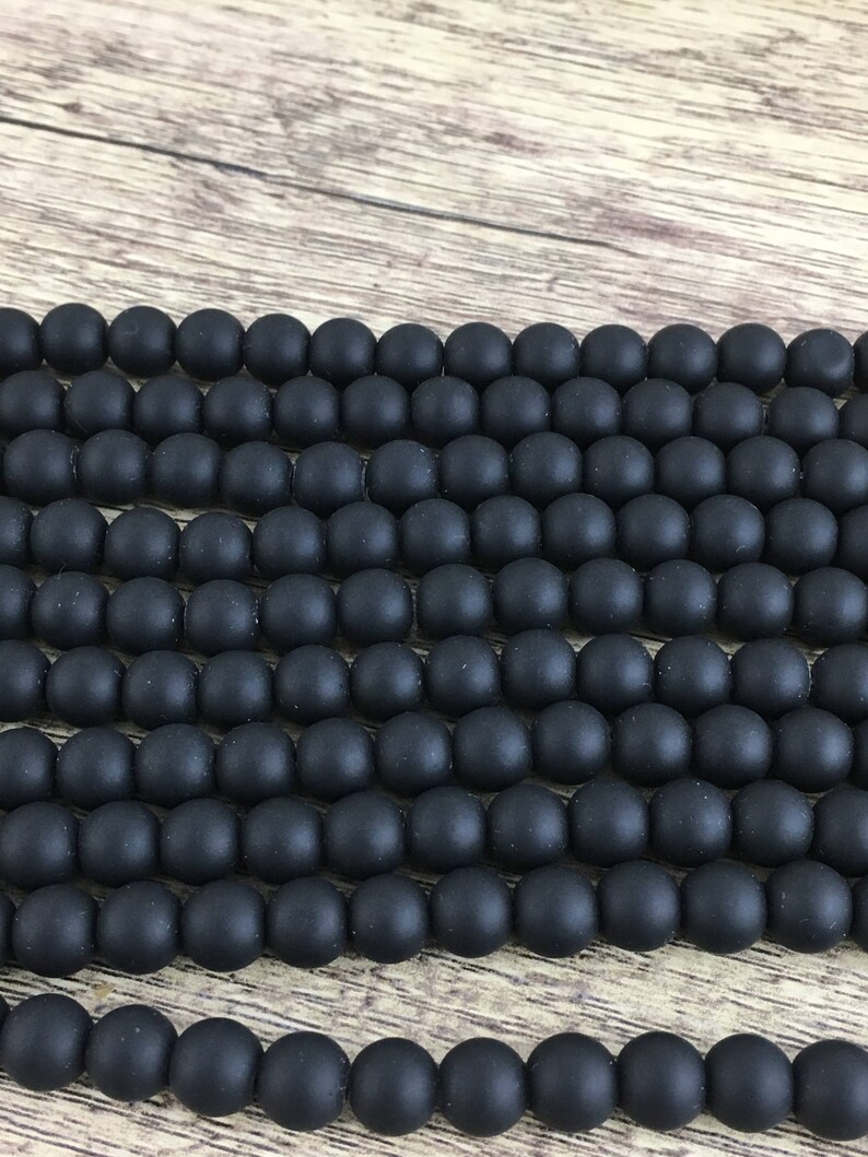 May include: A strand of black matte round beads. The beads are smooth and have a slightly textured surface.