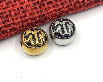 Può includere: Due perline rotonde in metallo con sfondo nero e lettere in rilievo dorate o argentate che dicono "Allah" in scrittura araba.
