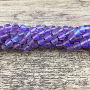 May include: A strand of iridescent purple glass beads. The beads are round and have a frosted finish.